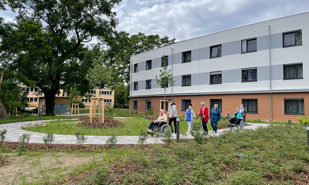 Pfleger und Senioren im Innenhof des Seniorenzentrums in der Arndtstraße Luckenwalde